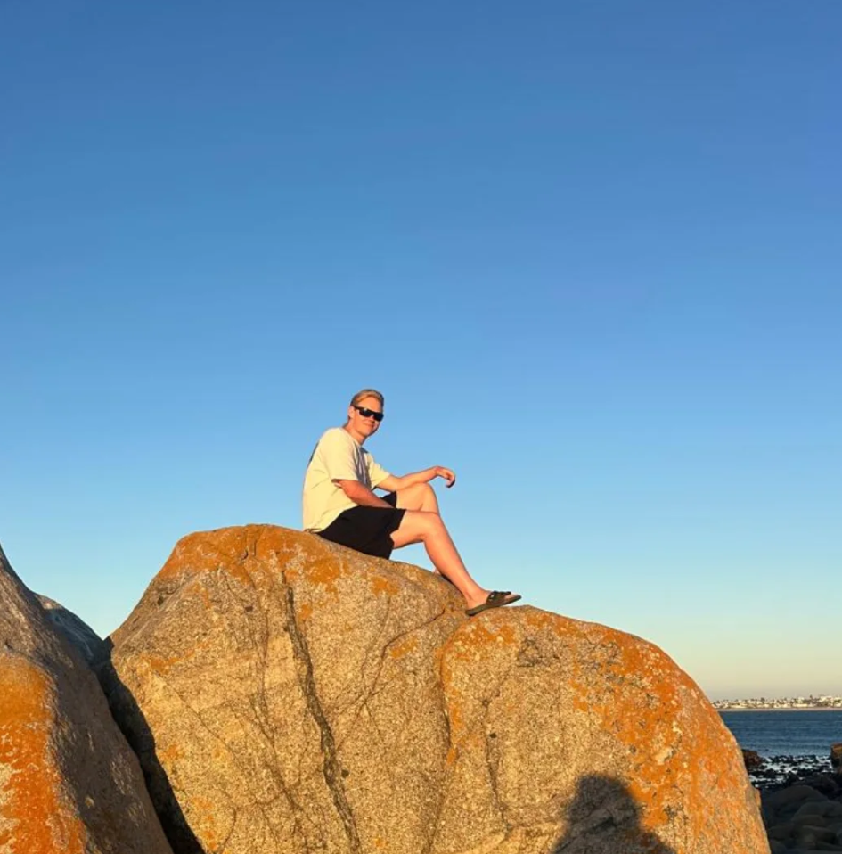 Matthew Lategan sitting on a rock at the coast